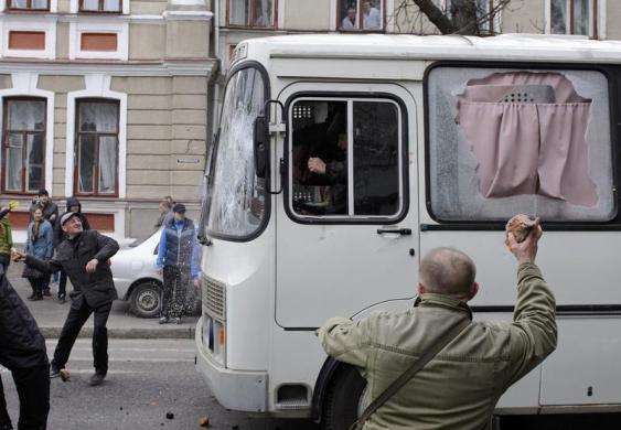 Pro-Russian protesters throw stones at an Interior Ministry bus near the regional administration building in Kharkiv Ukraine April 8 2014.
