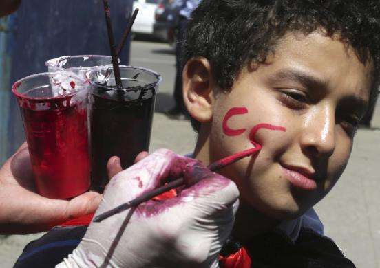 A child has CC painted on his face by supporters of presidential candidate and army chief Abdel Fatah al-Sisi during the Egyptian presidential elections in Cairo May 26 2014. Egyptians voted in an election expected to install army chief Abdel Fatah al-Si