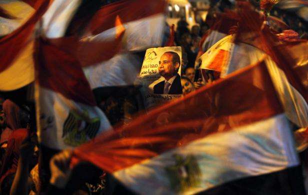 Supporters of Egypt former army chief Abdel Fattah al-Sisi hold a poster of him and wave flags in Tahrir square in Cairo May 27 2014.