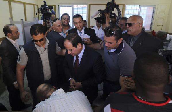 Presidential candidate and former army chief Abdel Fattah al-Sisi watches an election official before casting his ballot while voting at a polling station in Cairo May 26 2014.