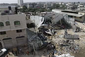 Palestinians inspect the site of an early morning Israeli airstrike in the al-Tuffah area on July 13, 2011
