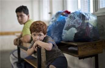 Palestinian children take shelter at a UN school after evacuating their home near the border in Gaza City on July 13, 2014
