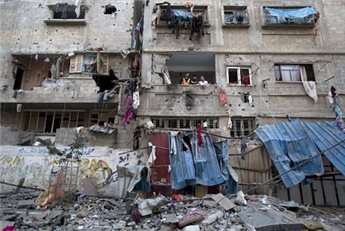Palestinians inspect damages following an Israeli air strike in Gaza City on July 10, 2014.