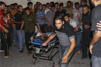 Palestinian medics wheel a wounded man into al-Najar hospital in Rafah, southern Gaza Strip, on July 7, 2014