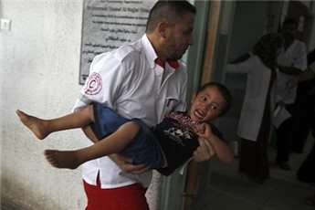 Paramedics carry a child into a hospital in Rafah, southern Gaza, following an Israeli airstrike.