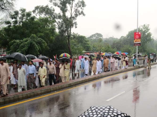 برستی بارش کے دوران شرکائے ریلی پارلیمنٹ کی جانب گامزن