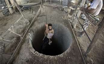 A Palestinian man is lowered into a smuggling tunnel beneath the Gaza-Egypt border, in the southern Gaza Strip, on Sept. 11, 2013