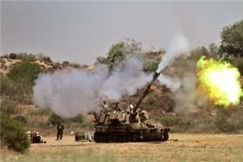Israeli soldiers of the 155mm artillery cannons unit fire towards the Gaza Strip from their position near Israel