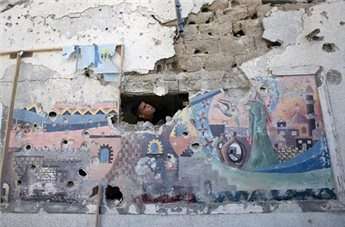 A Palestinian man inspects the damage at a UN school at the Jabaliya refugee camp in the northern Gaza Strip after the area was hit by Israeli shelling on July 30, 2014