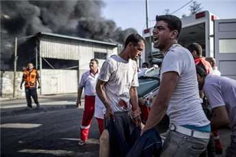 Palestinian emergency personnel evacuate a wounded man following an Israeli air strike on a market place in the Shujaiyya neighborhood near Gaza City, on July 30, 2014