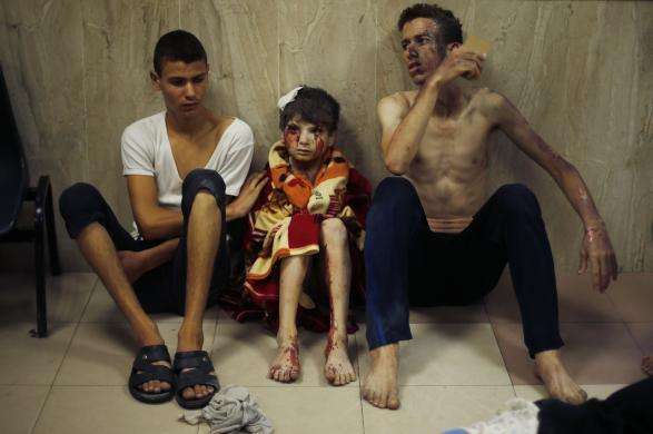 Two Palestinians who medics said were wounded in Israeli shelling sit at a hospital in Gaza City July 20 2014.