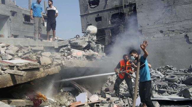 Palestinians extinguish a fire in a damaged building, which was hit in an Israeli strike, in Rafah, in the southern Gaza Strip on August 2, 2014.