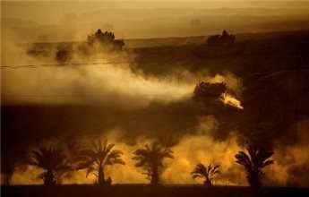 Three Israeli Merkava tanks drive back from the Gaza Strip to an Israeli base at the Israeli-Gaza border during the sunset on Aug. 3, 2014