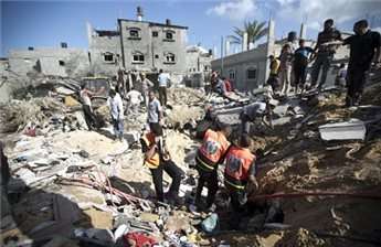 Palestinian rescue workers search through the rubble of a house that was hit by an Israeli military strike in Deir al-Balah, in the central Gaza Strip, on Aug. 3, 2014