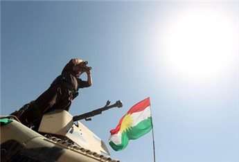 An Iraqi Kurdish Peshmerga fighter uses binoculars to monitor the area from their front line position in Bashiqa, a town 13 kilometers north-east of Mosul on August 16, 2014