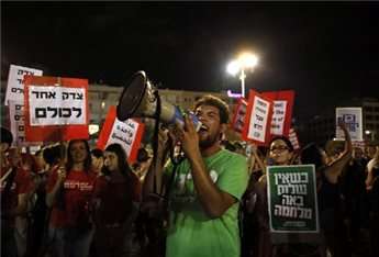 Demonstrators hold up placards reading in Hebrew: "One justice for all" (L) and "when there is no peace war comes" as thousands of Israelis protest during a left-wing peace rally in the coastal city of Tel Aviv on August 16, 2014