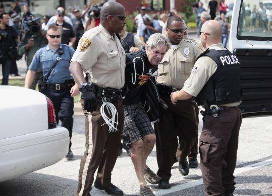 Police officers detain a demonstrator for protesting Michael Brown murder in Ferguson, Missouri August 18, 2014.