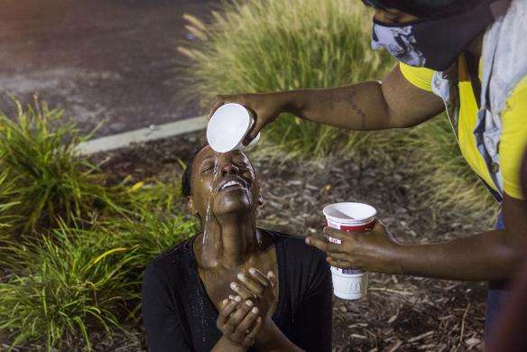 Protesters react to the effects of tear gas which was fired at demonstrators reacting to the shooting of Michael Brown in Ferguson, Missouri August 17, 2014.