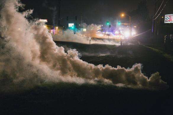 Tear gas rises from the ground after having been fired upon protesters who are continuing to react to the shooting of Michael Brown, in Ferguson, Missouri August 17, 2014.