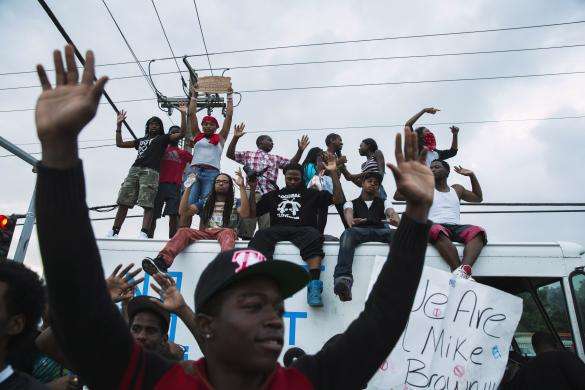 Demonstrators gesture and chant as they continue to react to the shooting of Michael Brown in Ferguson, Missouri August 17, 2014.