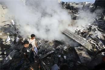 Palestinians inspect debris at the site of the killing of Muhammad Deif