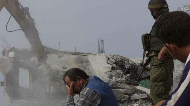 An Israeli bulldozer is demolishing the home of a Palestinian man