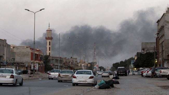 Smoke rises from buildings during clashes between Libyan security forces and militia groups in the eastern coastal city of Benghazi on August 23, 2014.
