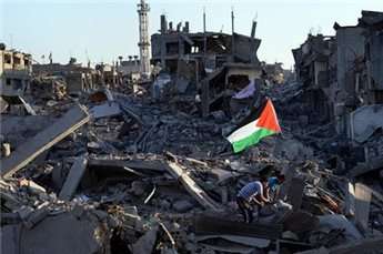 Residents walk through the rubble of their destroyed home as a Palestinian flag flutters in the wind, in the devastated neighborhood of Shujaiyya in Gaza City on Aug. 7, 2014