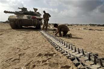 Israeli soldiers carry out work on their tank a few kilometers from the Gaza border on Aug. 6, 2014