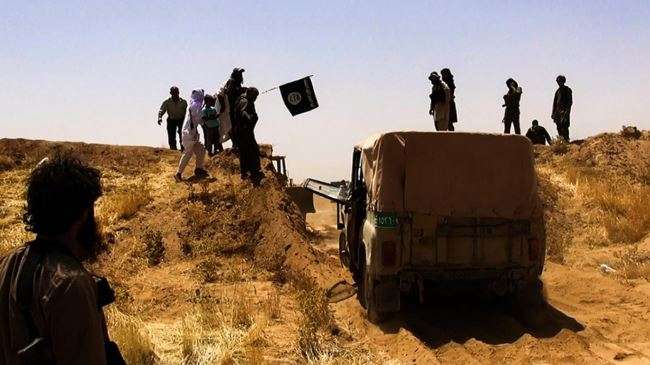 This file photo purportedly shows ISIL terrorists passing a newly cut road through the Syrian-Iraqi border.