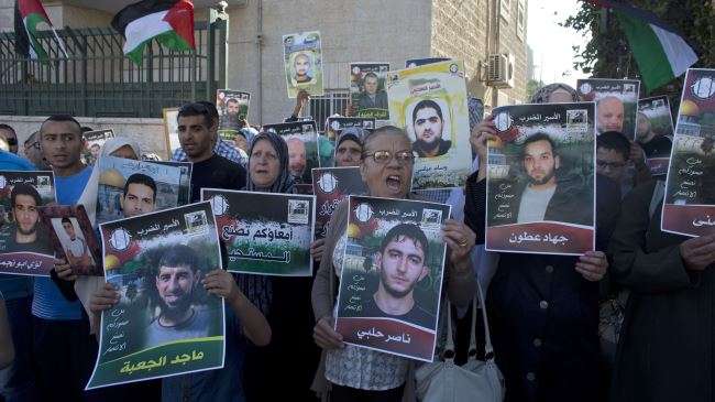 Palestinians demonstrate to show solidarity with hunger-striking Palestinian prisoners held by Israel, outside the Red Cross building in east al-Quds (Jerusalem) on June 12, 2014.