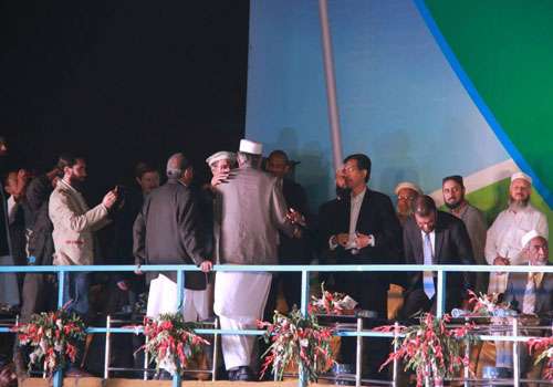 امیر جماعت اسلامی سراج الحق، اسٹیج پر غیر ملکی مہمانوں کا استقبال کر رہے ہیں