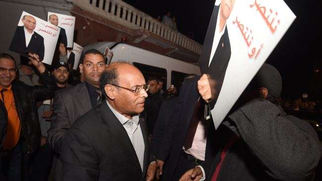 Tunisian presidential candidate Moncef Marzouki (C) greets supporters at his headquarters in the Ariana neighborhood in Tunis on November 23, 2014.