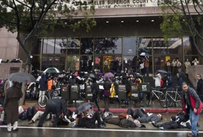 Protesters lie on the ground in the rain outside Stanley Mosk Courthouse in downtown LA on December 16, 2014.