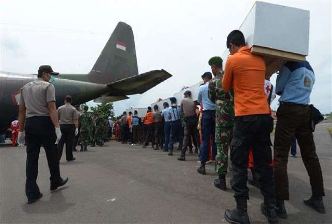 Indonesian officers carry coffins with the remains of passengers of AirAsia flight QZ8501.