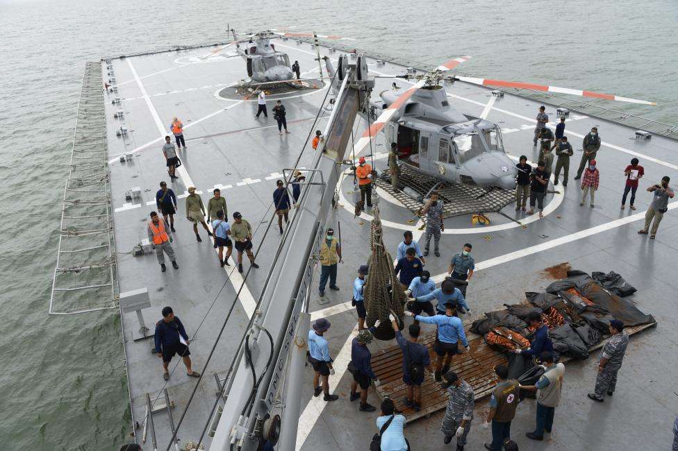 Indonesian Navy personnel evacuate recovered dead bodies of passengers from AirAsia flight QZ8501, on the the deck of the Indonesian Navy vessel KRI Banda Aceh, at sea, January 3, 2015.