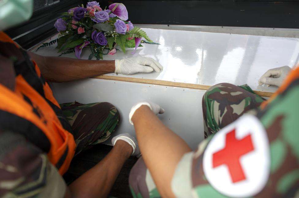 ndonesian military personnel sit next to caskets containing the remains of passengers onboard AirAsia flight QZ8501, recovered off the coast of Borneo, at a military base in Surabaya, January 3, 2015.