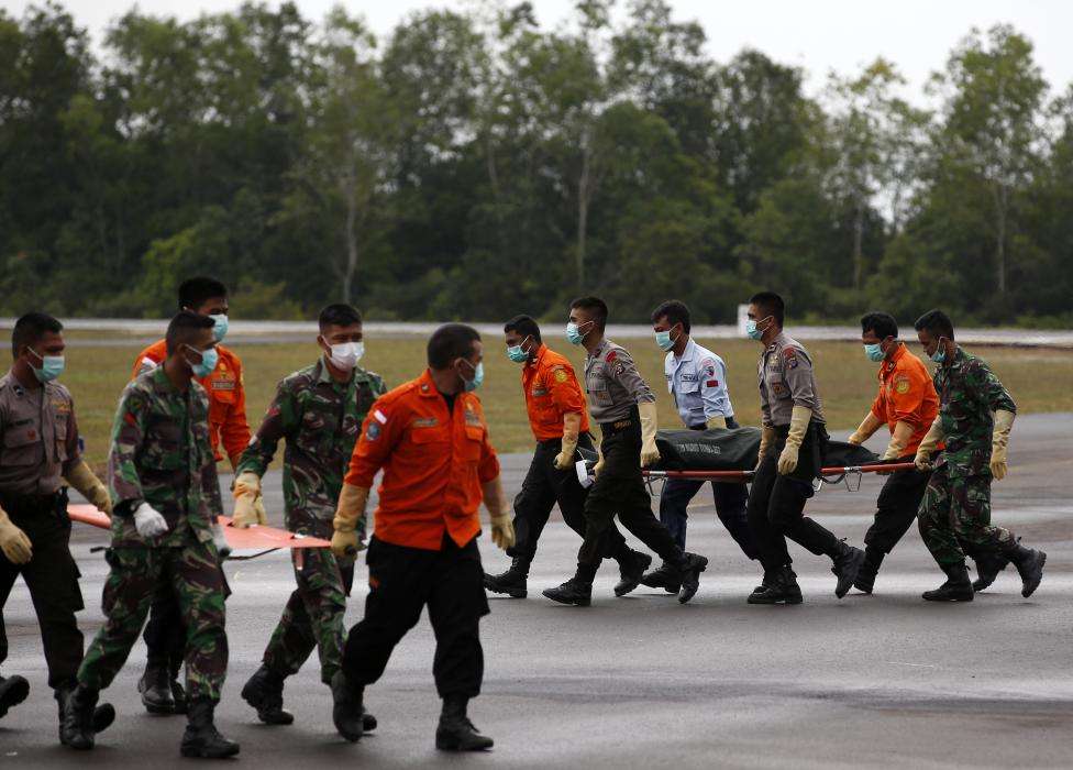 The body of an AirAsia QZ8501 passenger is carried to an ambulance after being transported from a ship by a U.S. Navy helicopter from the USS Sampson at the airbase in Pangkalan Bun, Central Kalimantan, January 4, 2015.