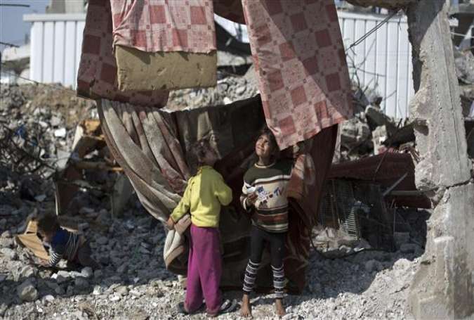 Palestinian children play amidst debris of houses, which were destroyed during the 50-day Israeli war last summer, in the Gaza Strip town of Beit Hanun, March 13, 2015.