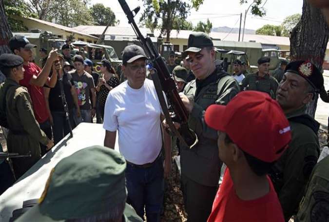 Venezuelan Defence Minister Vladimir Padrino Lopez (C) handles a Kalashnikov rifle during an exercise in Valencia, 120 km west of Caracas on March 21, 2015.