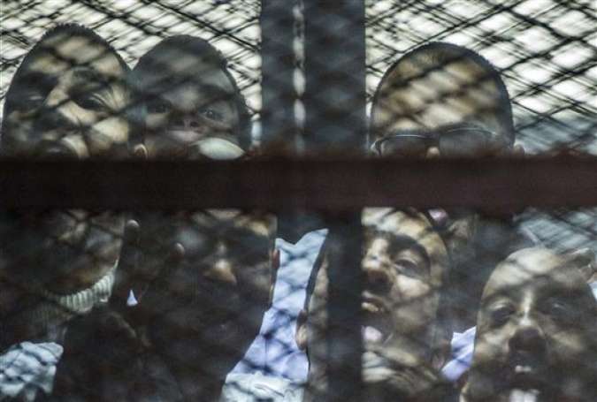 Egyptian defendants stand behind bars as they wait for the verdict in their trial at a police institute in Cairo, Egypt, February 23, 2015.