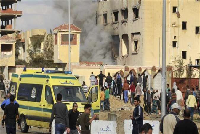 People gather at the site of a car bomb explosion that targeted a police station in North Sinai’s provincial capital of el-Arish, Egypt, April 12, 2015.