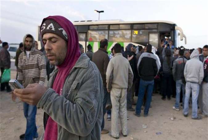 Palestinian laborers queuing to use buses to travel from the West Bank into Israel for work.