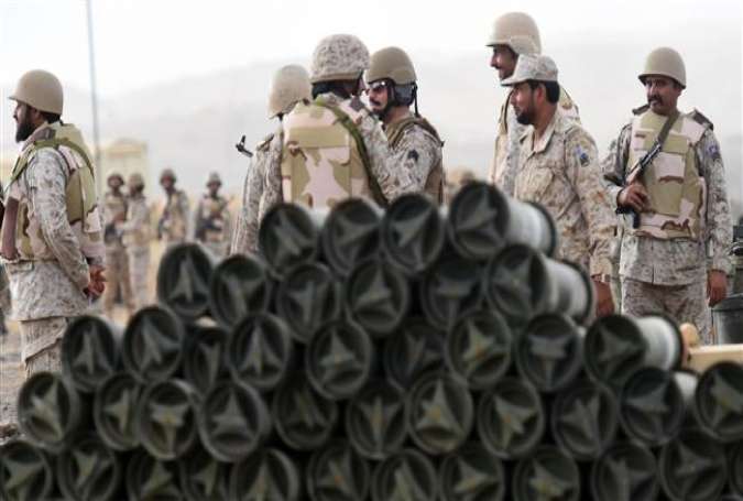 Saudi soldiers from an artillery unit stand behind a pile of ammunition at a position close to the Saudi-Yemeni border, in southwestern Saudi Arabia, on April 13, 2015.