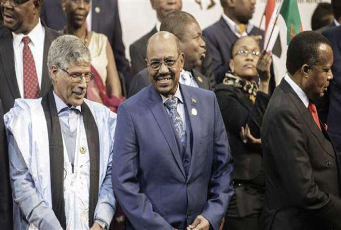Sudanese President Omar al-Bashir (C) arrives for a group photograph of leaders at the 25th African Union Summit in Johannesburg, South Africa, June 14, 2015.