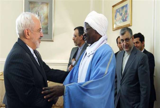 Iran’s Foreign Minister Mohammad Javad Zarif (L) shakes hands with the outgoing Sudanese Ambassador to Tehran, Mirghani Abbaker Eltayeb Bakhit, on June 14, 2015.