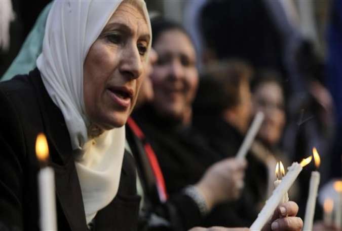 Egyptian Muslim women light candles during a vigil