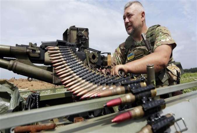 A Ukrainian serviceman checks his machine-gun as he holds a position in Krymske village, Lugansk, on June 25, 2015.