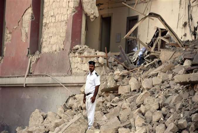 An Egyptian policeman stands in the rubble at the site of a powerful bomb explosion that ripped through the Italian consulate, killing one person, in the Egyptian capital, Cairo, July 11, 2015.