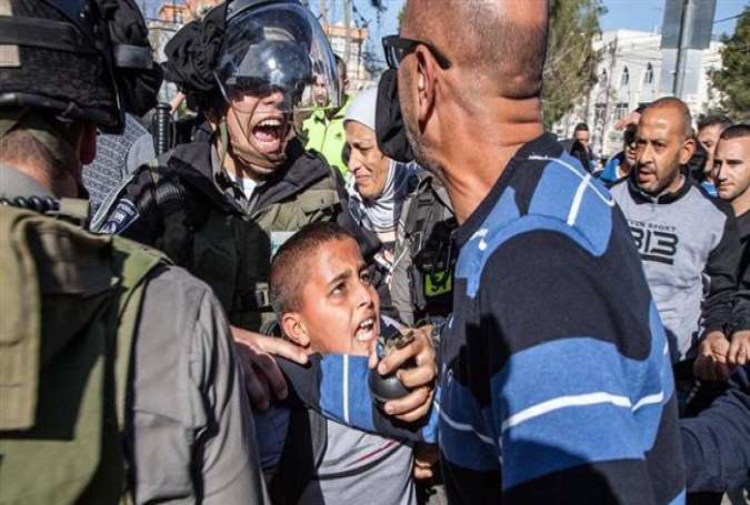 Israeli forces arresting a Palestinian boy in front of his school in East al-Quds (Jerusalem)